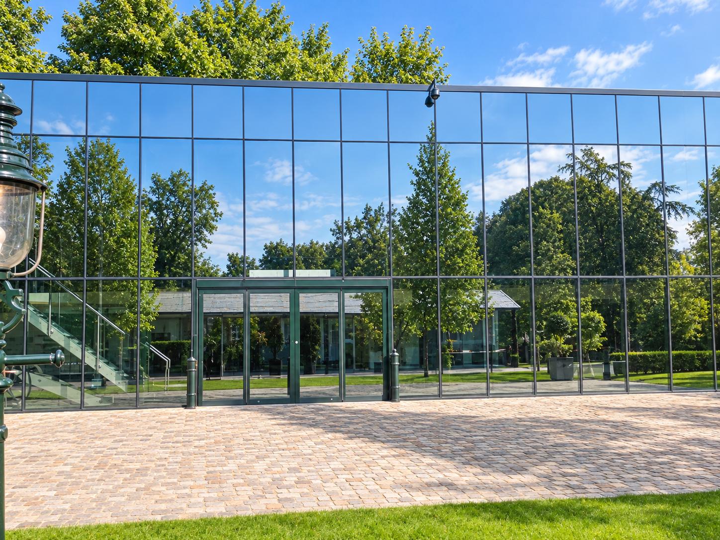 Silicone glazed curtain walling and entrance doors at Flint Mill, Wetherby, reflecting the surrounding trees